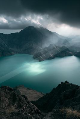 A dramatic long exposure landscape of mountains, lake, valley.