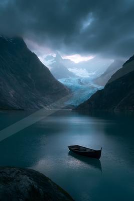 A blue hour water scene of lake, mountains, valley.