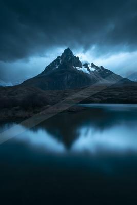 A blue hour long exposure water scene of lake, mountains, reflection.