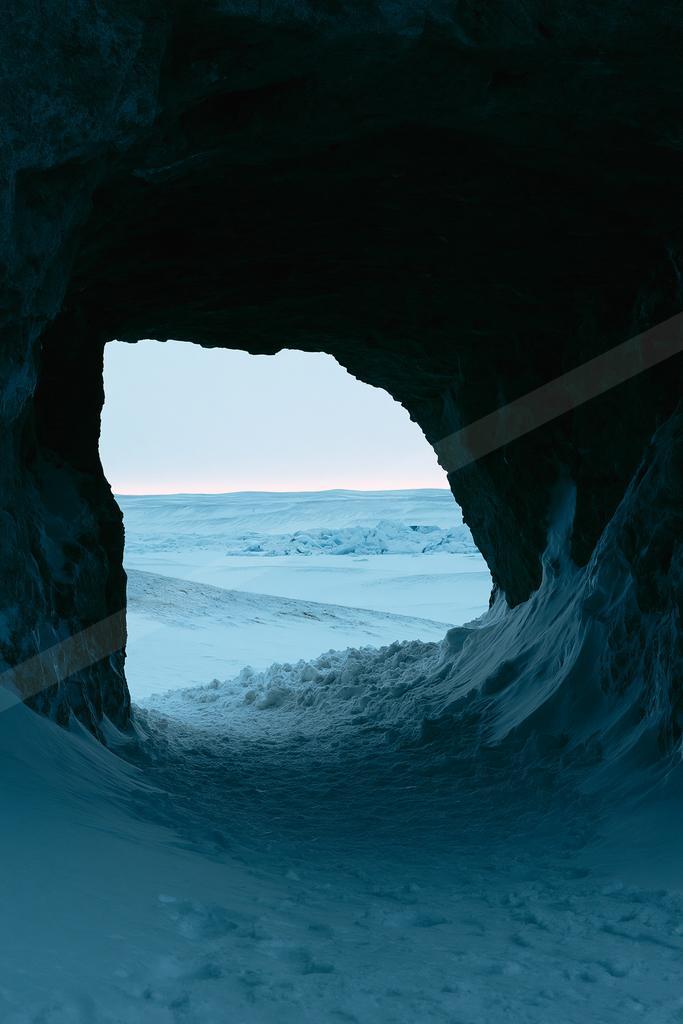 A blue hour negative space landscape of a cave, ice.