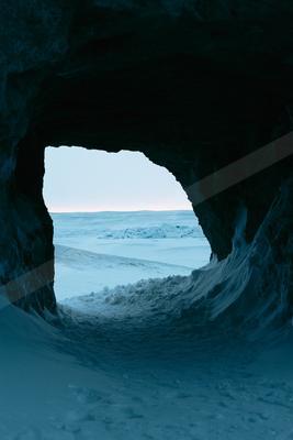 A blue hour negative space landscape of a cave, ice.