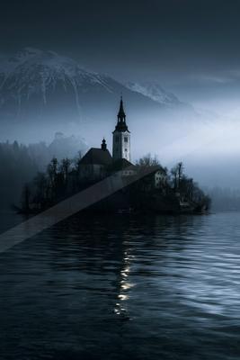 A brown-toned moody photograph of lakeside, beacon, church.