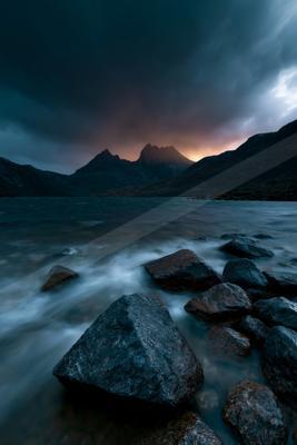 A black-toned moody photograph of lakeside, valley, seashore.