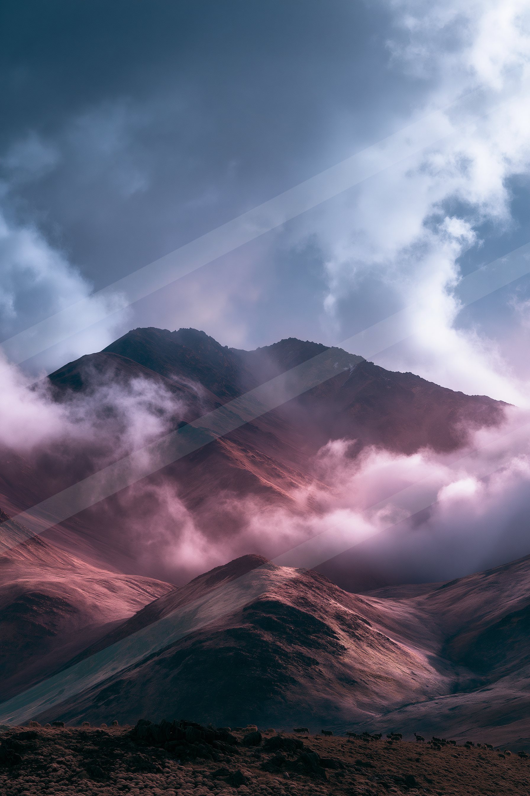 A breathtaking view of towering mountain peaks partially obscured by swirling clouds bathed in a soft pink glow, suggesting sunset lighting.