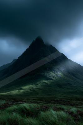A dramatic landscape of mountains, fog.