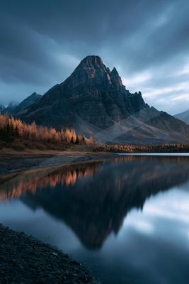 A blue hour long exposure water scene of lake, mountains, reflection.