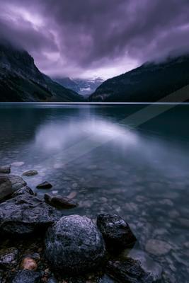 A brown-toned moody photograph of lakeside, valley, breakwater.