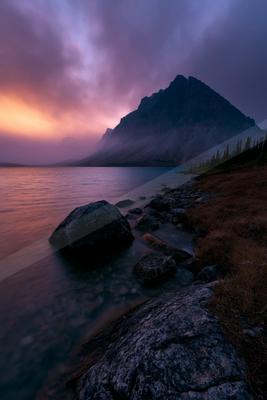 A blue hour long exposure water scene of lake, mountains, sunrise.