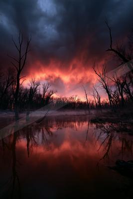 A moody water scene of lake, storm, sunset.