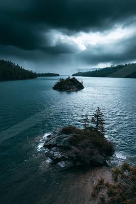 A gray-toned moody photograph of lakeside, promontory, seashore.