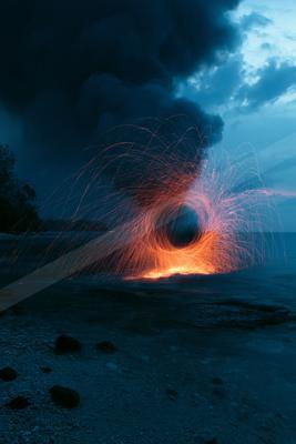 A black-toned moody photograph of volcano, lakeside, geyser.
