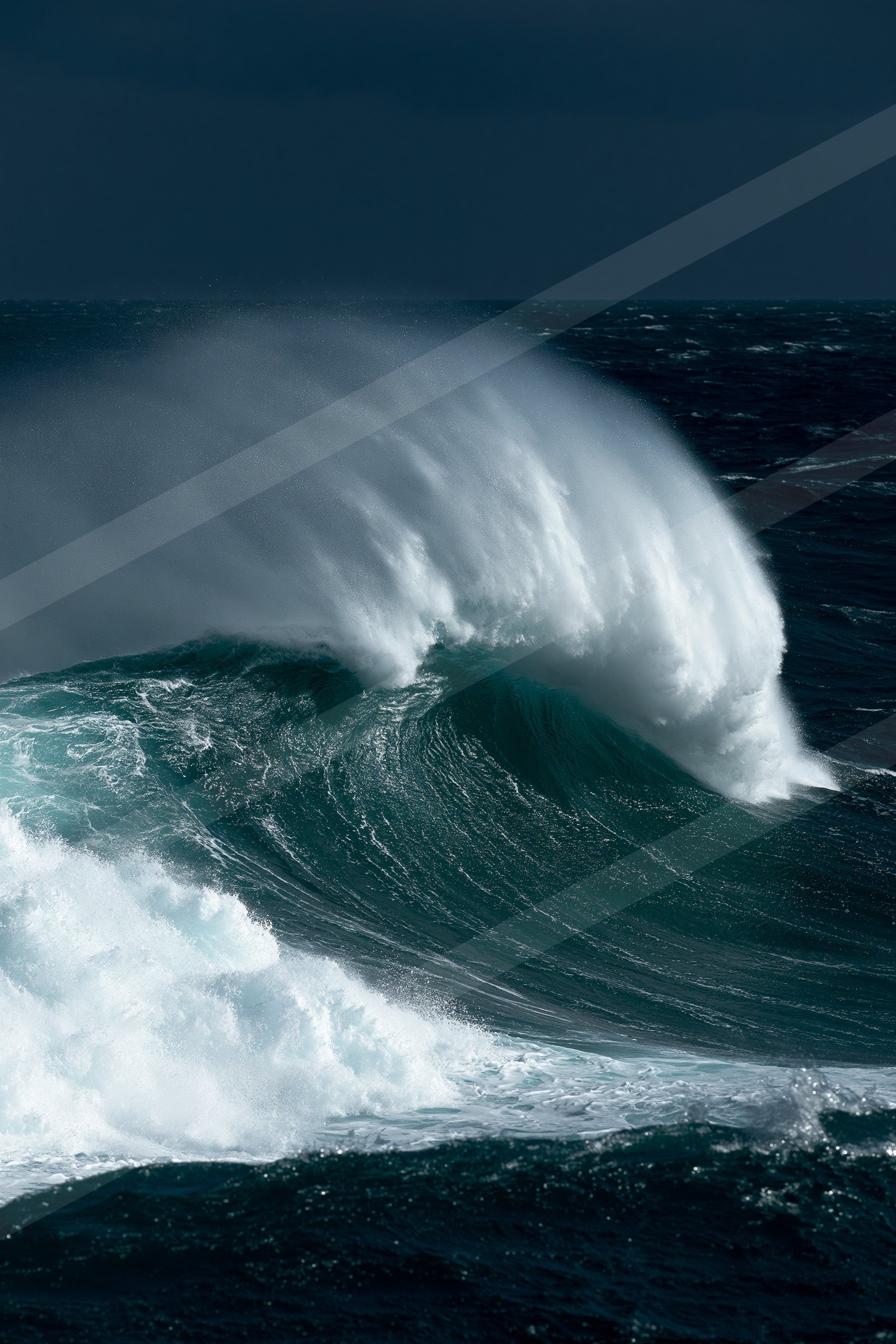A powerful ocean wave curls and crashes under a dark, moody sky.