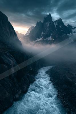 A dramatic landscape of mountains, valley, river.