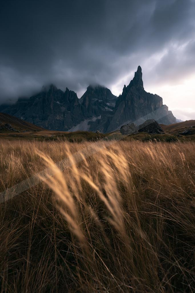 A dramatic landscape of mountains, field.