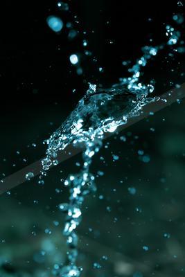 A close-up of water splashing with bubbles against a dark backdrop.