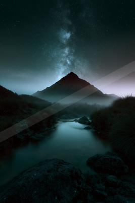 A night long exposure landscape of mountains, starry sky, lake.