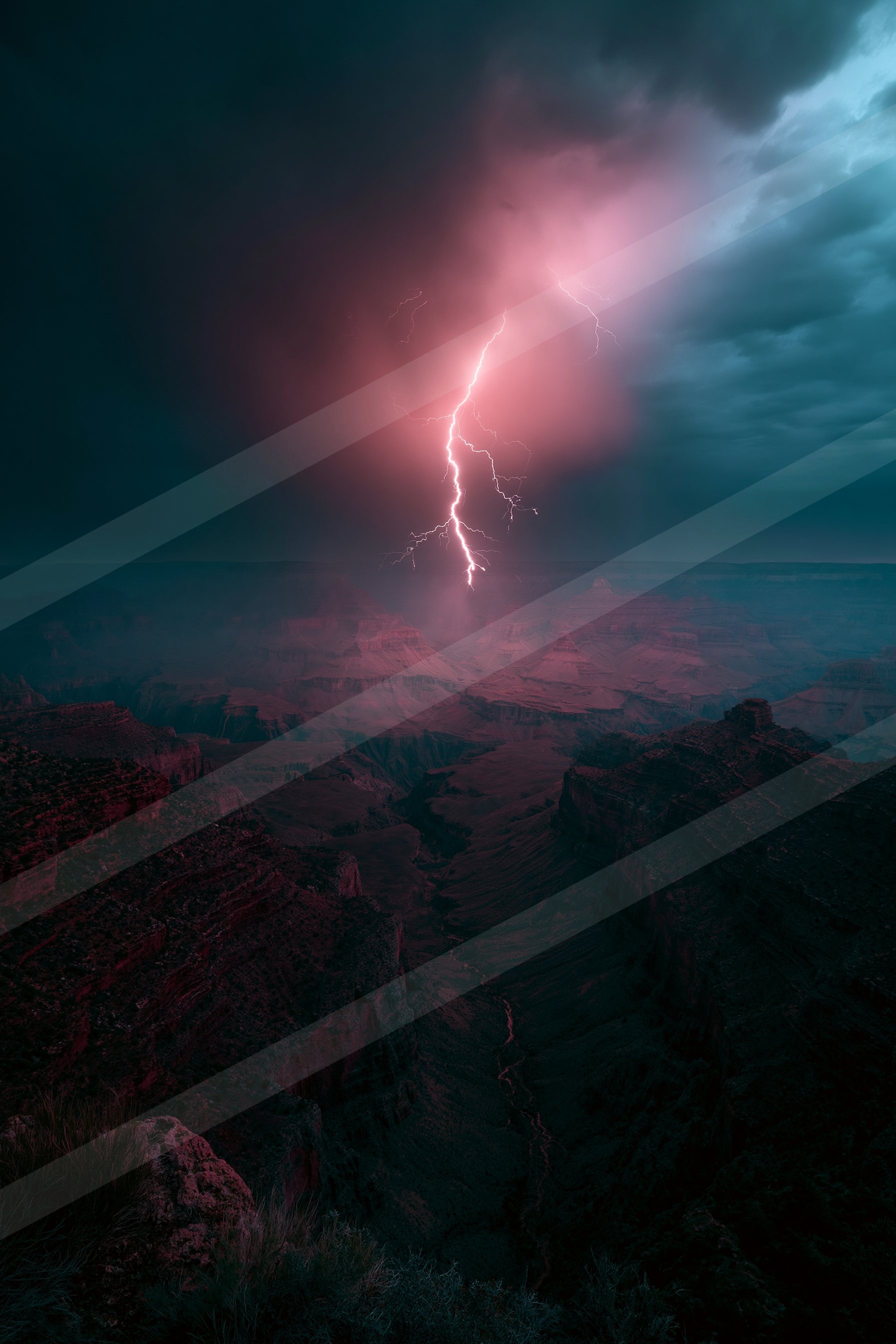 A powerful lightning bolt illuminates the night sky over a rugged canyon landscape.