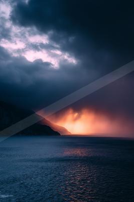 A dramatic high contrast sky scene of a sunset, reflection.