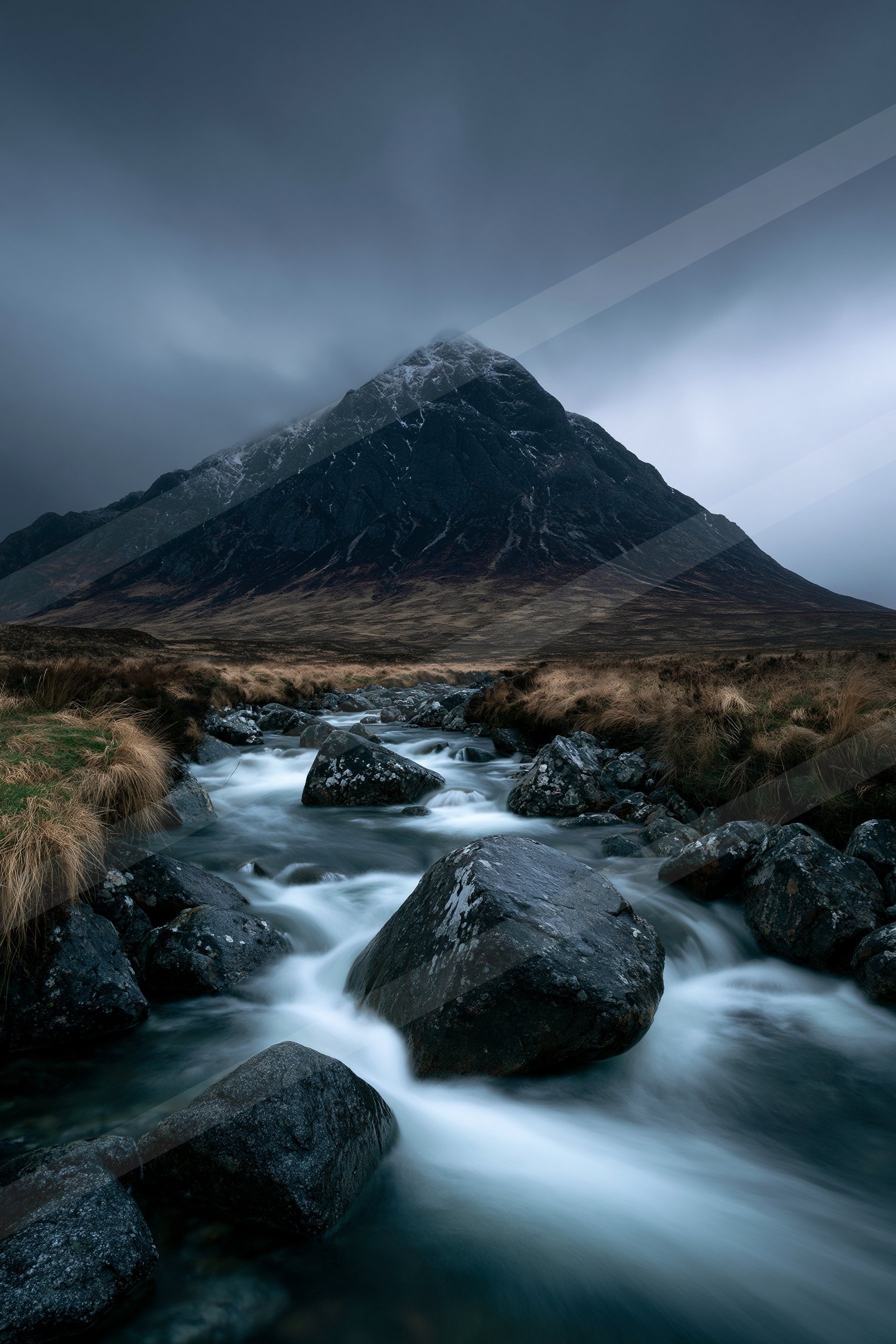 A dramatic long exposure water scene of a stream, rocks.