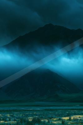 A blue hour landscape of mountains, storm.