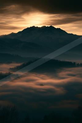 A brown-toned moody photograph of alp, volcano, valley.