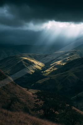A dramatic sky scene of storm, mountains, valley.