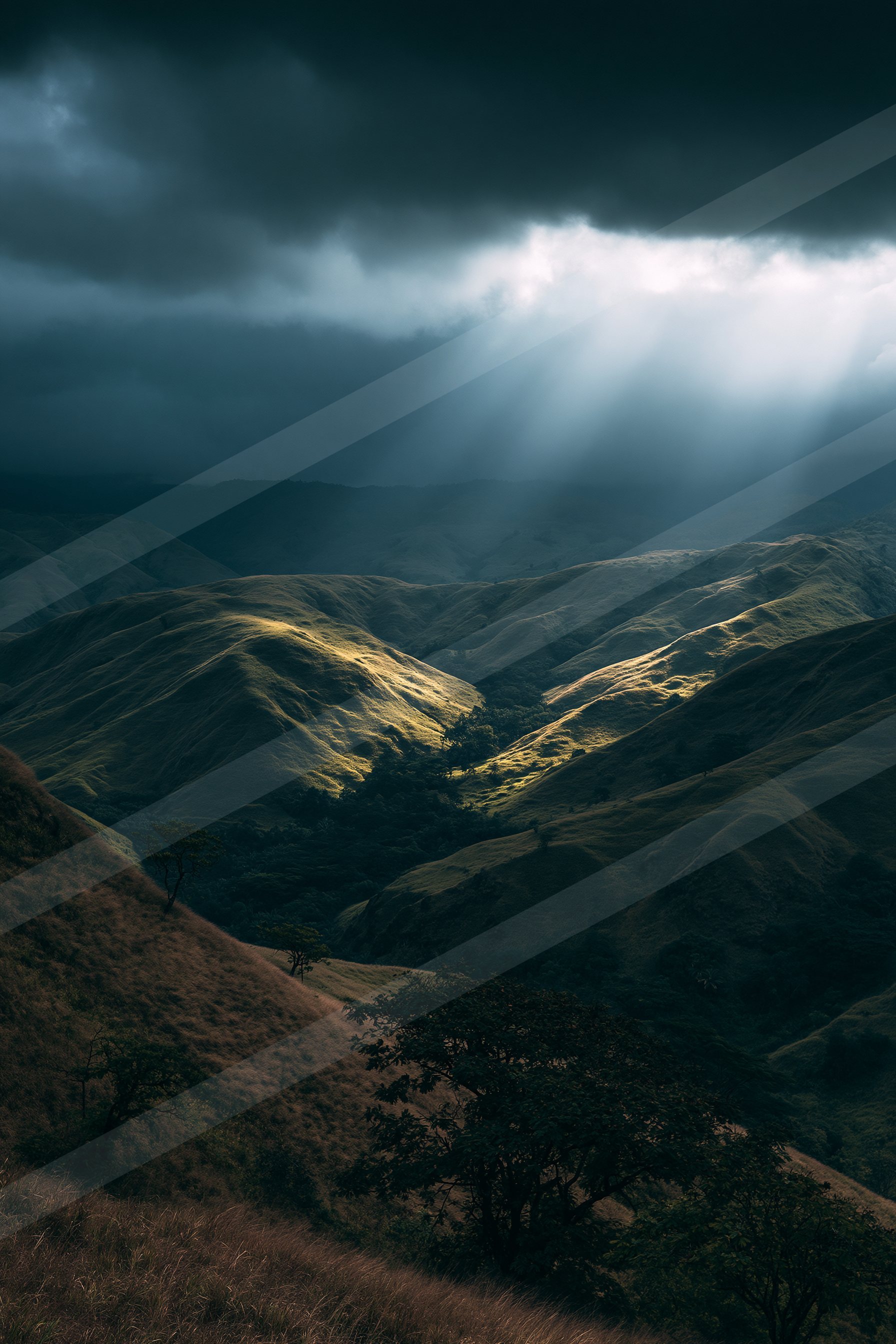 A moody landscape of rolling hills under a stormy sky, illuminated by dramatic sunbeams breaking through the clouds.