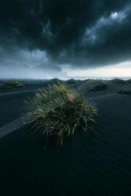 A moody sky scene of storm, field, lake.
