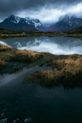 A blue hour long exposure water scene of lake, mountains, reflection.