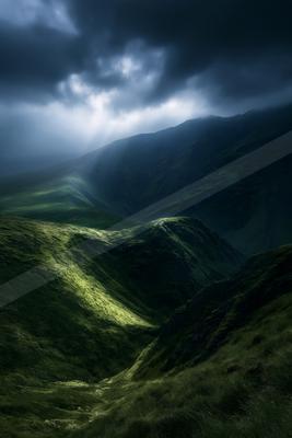 A dramatic landscape of valley, mountains, storm.
