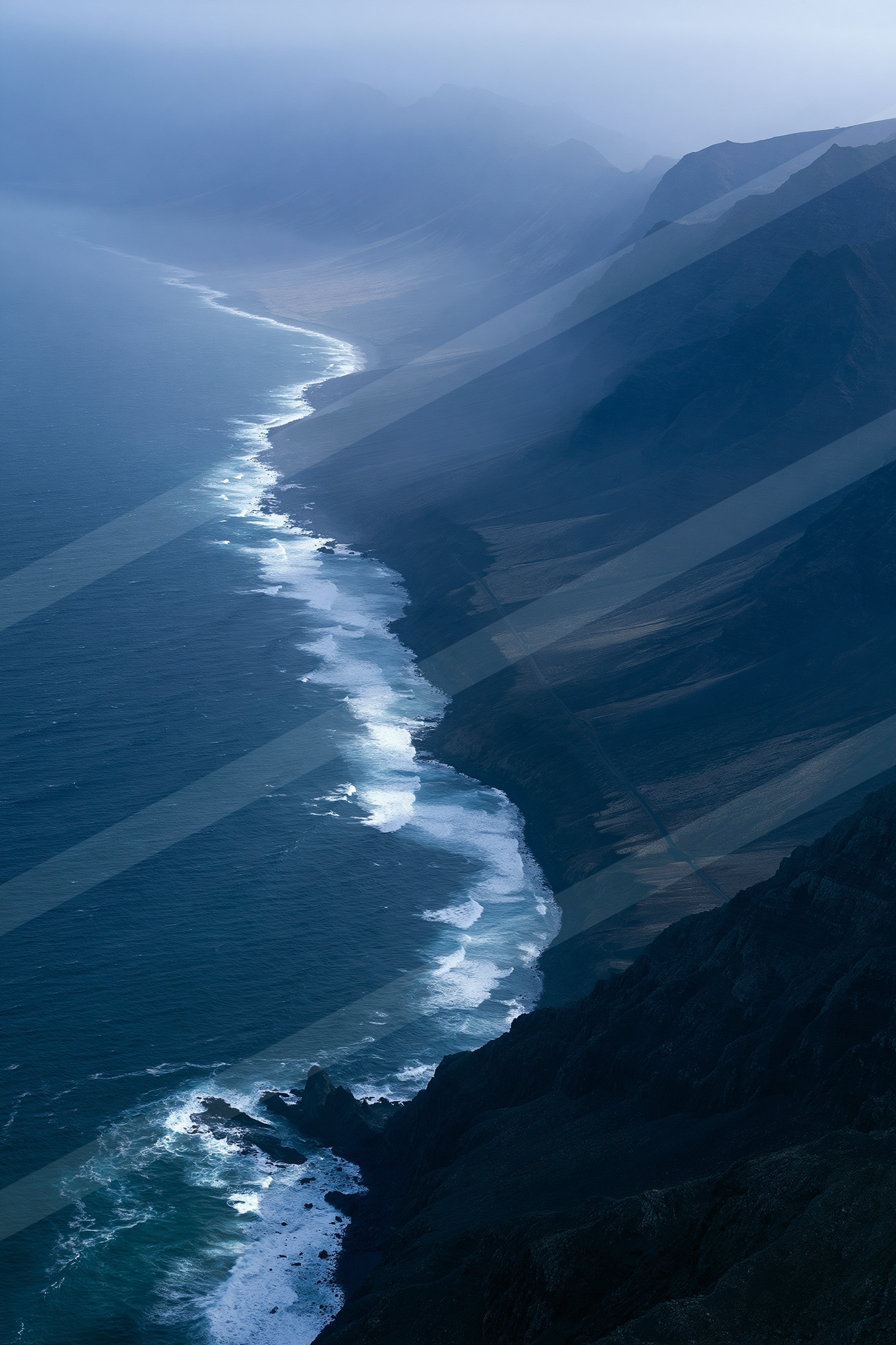 A moody aerial water scene of a coastline, sand.
