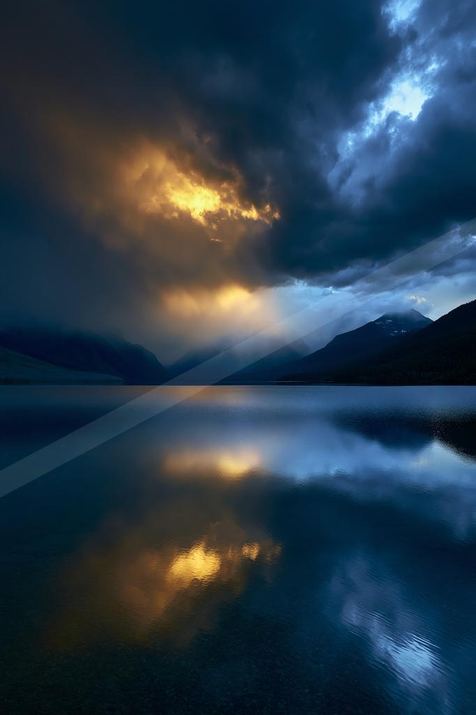 A blue hour long exposure water scene of lake, storm, clouds.