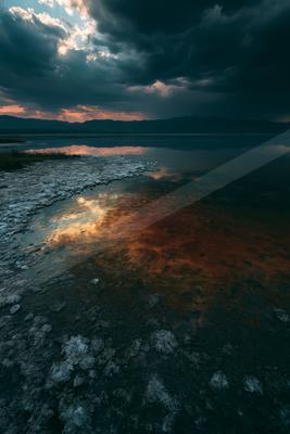 A moody sky scene of clouds, lake, storm.