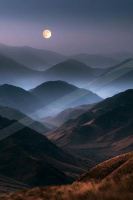 A night landscape of mountains, valley, fog.