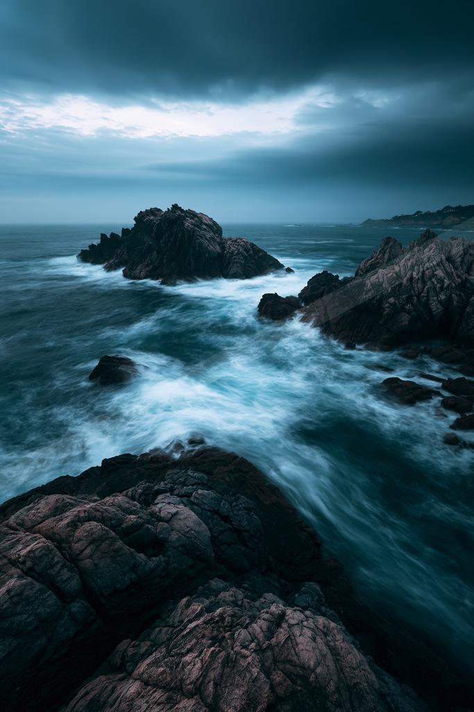 A blue hour long exposure water scene of ocean, rocks.