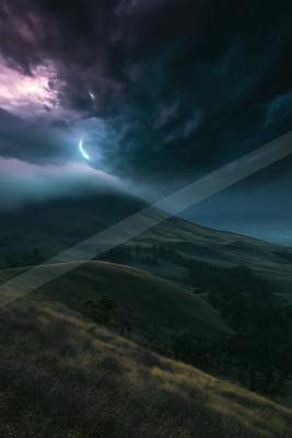 A night sky scene of storm, clouds, mountains.