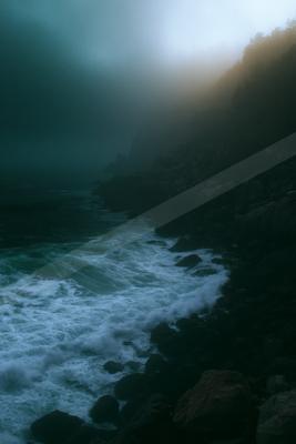 A blue hour water scene of ocean, waterfall, beach.