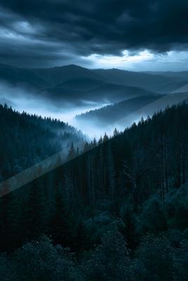 A mysterious high contrast landscape of a valley, fog.