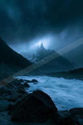 A night long exposure landscape of mountains, storm, ocean.