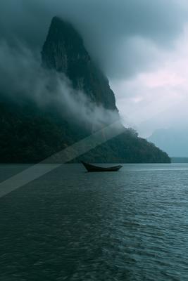 A dramatic still life of boat, lake, ocean.