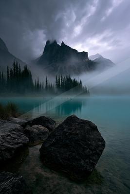 A brown-toned moody photograph of lakeside, valley, alp.