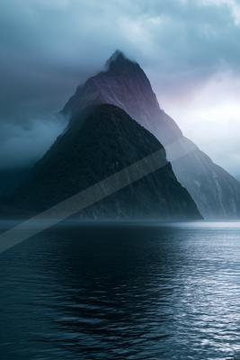 A serene landscape of mountains, lake, fog.