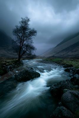A moody water scene of river, waterfall, valley.