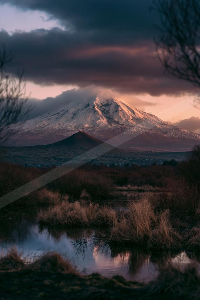 A dramatic landscape of mountains, lake.