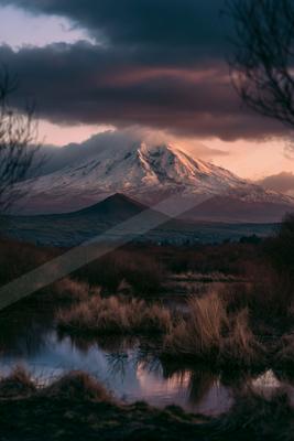 A dramatic landscape of mountains, lake.