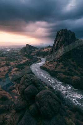 A moody water scene of river, waterfall, valley.