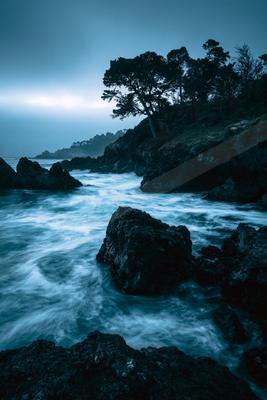 A blue hour long exposure water scene of ocean, storm, river.