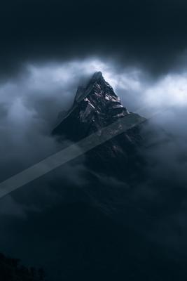 A towering mountain peak piercing through a dense layer of storm clouds, illuminated by subtle light against a dark sky.