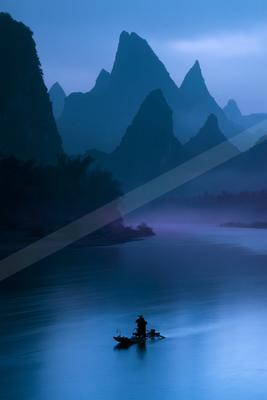 A blue hour landscape of mountains, lake, valley.