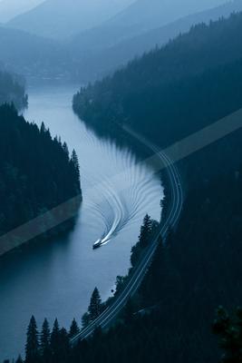 A moody water scene of river, bridge, valley.